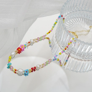 Détail macro du collier ras de cou avec perles colorées et fleurs pour l'été