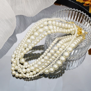 Macro detail of multilayer gradient pearl necklace with elegant gold lobster clasp