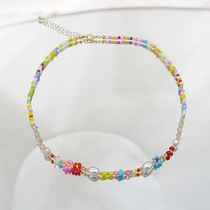Détail d'un collier de perles colorées avec petites fleurs et perles de nacre