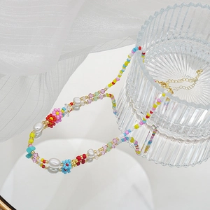 Collier ras du cou perles colorées et fleurs artisanales sur fond de tulle élégant