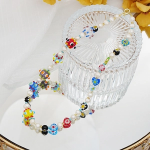 Gros plan du collier de perles d'eau douce fait main avec perles en verre millefiori