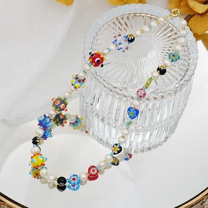 Détail d'un collier de perles fait main avec perles en verre millefiori sur base en verre