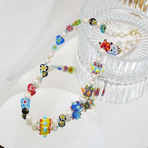 Détail de perles d'eau douce faites main et perles de verre millefiori colorées sur collier