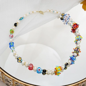 Détail du collier de perles fait main avec breloques en verre millefiori et motifs cœurs