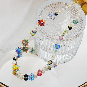Détail d'un collier de perles d'eau douce avec des perles en verre millefiori