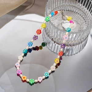 Collier de perles coloré avec fleurs en argile et perles sur support en verre