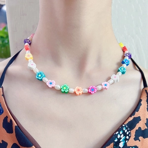 Détails des perles de fleurs colorées et perles blanches sur ce collier d'été chic