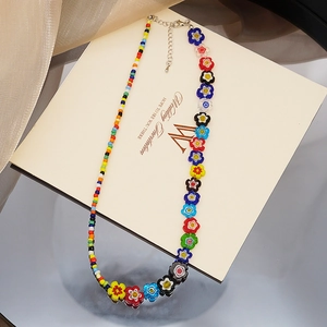 Détail d'un collier de perles de fleurs en verre colorées avec fermoir en métal argent