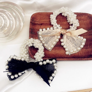 Elegant pearl bow scrunchies set featuring lace ribbon accents on a wooden tray
