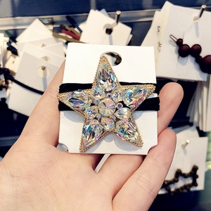 Close-up of star-shaped hair tie with sparkling crystals and golden metal base