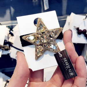 Golden star-shaped hair tie with sparkling crystals and a high-elastic black rubber band