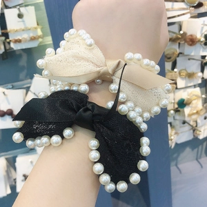 Elegant pearl-rimmed lace bow scrunchies in black and beige for stylish hair styling