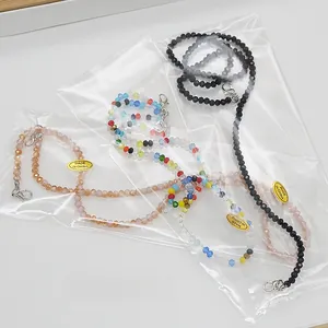 Détail de chaînes de lunettes en perles de cristal en sachets avec fermoirs mousqueton
