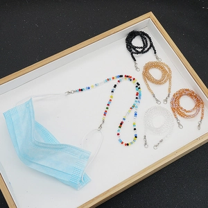 Détail d'une chaîne de lunettes en perles colorées avec fermoir argenté sur un masque