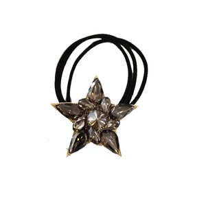 Elegant star crystal hair tie with grey faceted stones and gold metal trim on white background