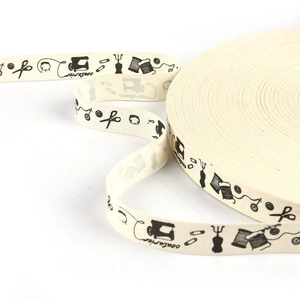 Close-up of vintage printed cotton ribbon with sewing tools patterns and French text