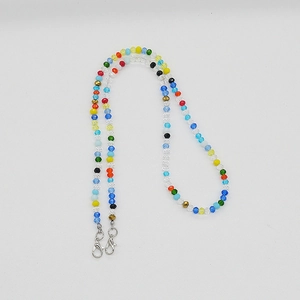 Détail des perles en cristal facettées colorées sur un cordon avec fermoirs mousquetons