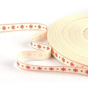 Detail of Christmas cotton ribbon roll with red snowflake pattern for DIY gift wrapping