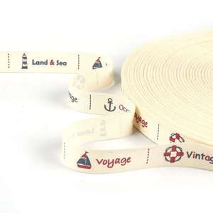 Detail of nautical cotton ribbon rolls with printed anchors and lighthouses for DIY crafts