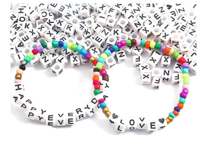 Macro shot of DIY bracelets featuring 6mm acrylic alphabet beads with HAPPY EVERYDAY text