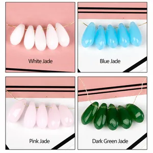 Dettaglio macro di perle di vetro ceche a goccia in bianco blu rosa e verde scuro per il fai da te