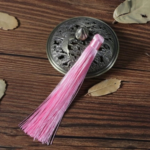 Ciondolo a nappa rosa per forcine fai-da-te su sfondo di legno vintage classico