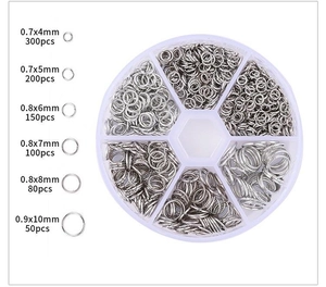 Detail of 4-10mm silver open jump rings in a transparent storage case for DIY jewelry