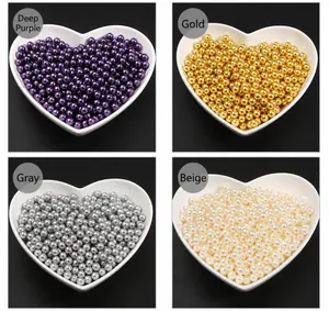 Macro detail of multicolored imitation pearls in heart trays for DIY jewelry making