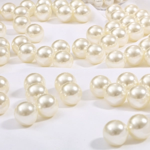 Lustrous ivory white round faux pearls scattered on silk fabric for jewelry DIY