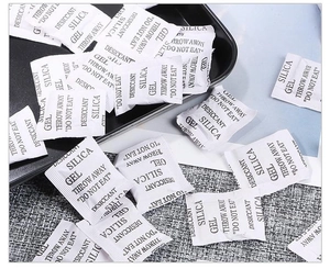 Macro shot of silica gel desiccant packets in breathable white packaging for moisture protection