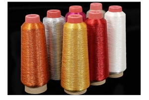 Close-up of vibrant metallic embroidery threads in various colors on black background