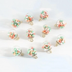 Detailed close-up of 10 clear glass ball pendants filled with colorful star sequins