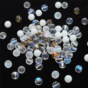 Mélange de perles rondes mates et irisées pour bijoux DIY sur fond sombre