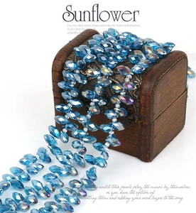 Detailed close-up of faceted blue glass beads for DIY jewelry making on a wooden box