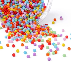 Mix of colorful round glass seed beads pouring from a cylinder for DIY jewelry making
