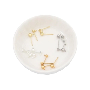 Macro view of three-color ball stud earrings with hanging loops for DIY jewelry
