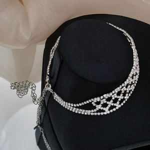 Detailopname van een zilveren choker met strassteentjes en mesh-ontwerp op zwart fluweel