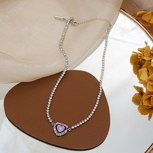 Detail der silbernen Tenniskette mit lila Herzanhänger und bunten Mikro-Diamanten