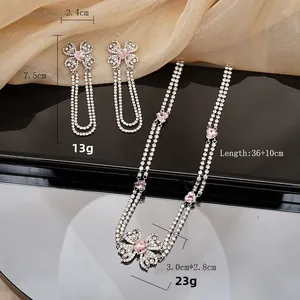 Detail shot of silver floral necklace and tassel earrings with pink heart crystals and rhinestones