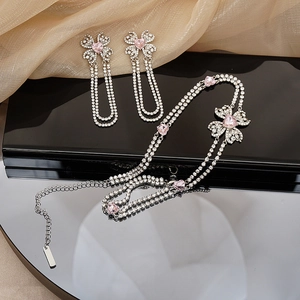 Detail of luxury rhinestone choker necklace and tassel earrings with pink heart stones