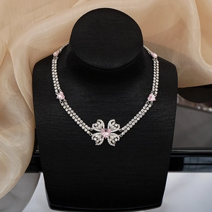 Close-up of double-layer silver choker with pink heart crystals and butterfly pendant