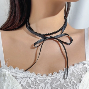 Close-up of black beaded choker necklace with a delicate satin ribbon bow and long ties