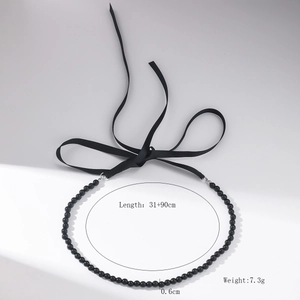 Detail of vintage beaded necklace with black crystals and adjustable ribbon tie closure
