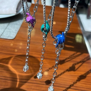 Modern metallic knot necklace with colorful enamel hand pendants and crystal drop detail