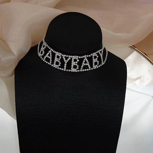 Gros plan du collier choker BABYBABY en strass argenté sur un support en velours noir