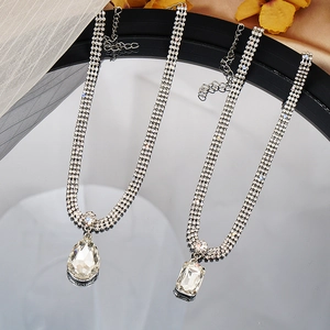Detalle de colgantes de cristal en forma de gota y esmeralda en collares de tres filas