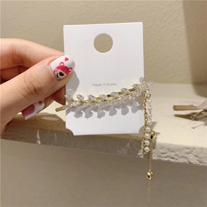 Détail de la pince à cheveux coréenne avec strass brillants et pompons en perles