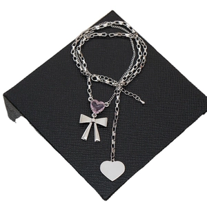 Collar de capas plateado con cristal de corazón rosa y colgante de lazo para mujer