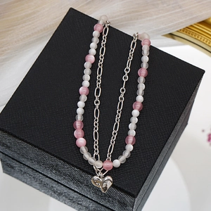 Collier double rang avec perles œil de chat et pendentif cœur sur boîte à bijoux noire