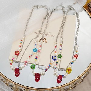 Détail du collier fraise avec perles d'eau douce sur un plateau en miroir doré